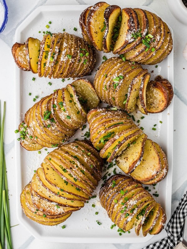 Freshly baked Hasselback Potatoes served on a white plate.