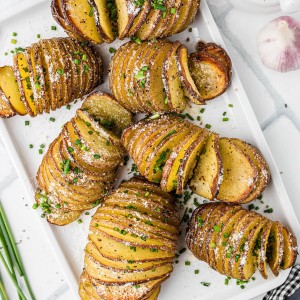 Freshly baked Hasselback Potatoes served on a white plate.