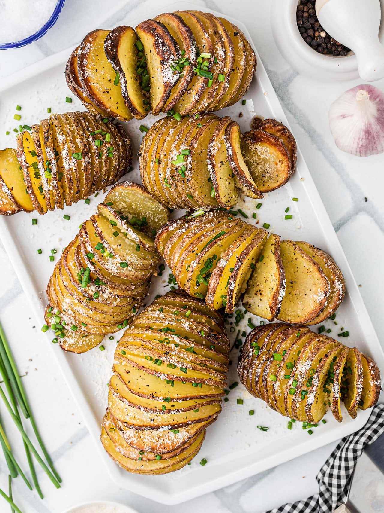 Freshly baked Hasselback Potatoes served on a white plate.