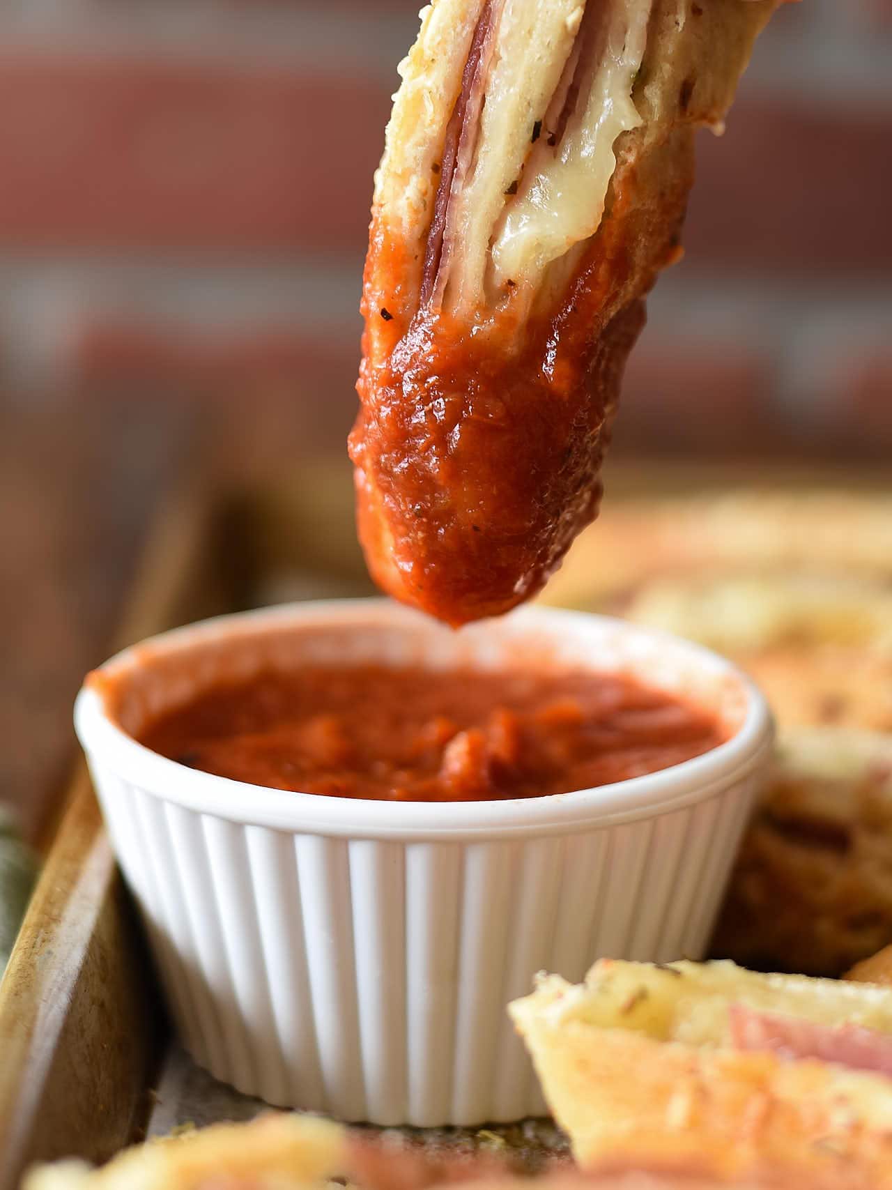 Dipping a slice of Stromboli into marinara sauce.