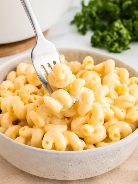 Creamy Homemade Mac and Cheese in a bowl with a fork twirling cheesy pasta.