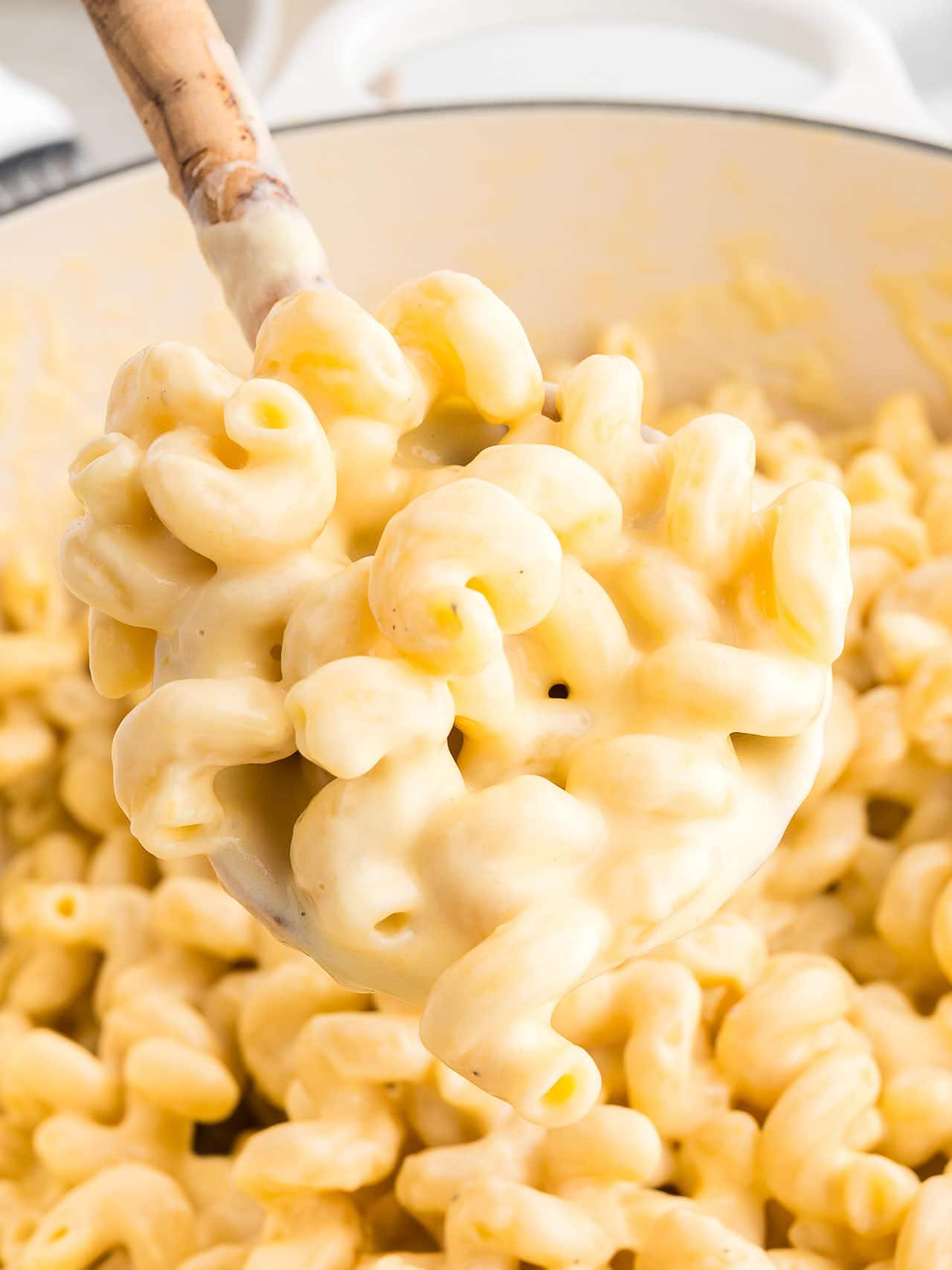 Spoonful of creamy Homemade Mac and Cheese showing rich cheese sauce coating cavatappi pasta.