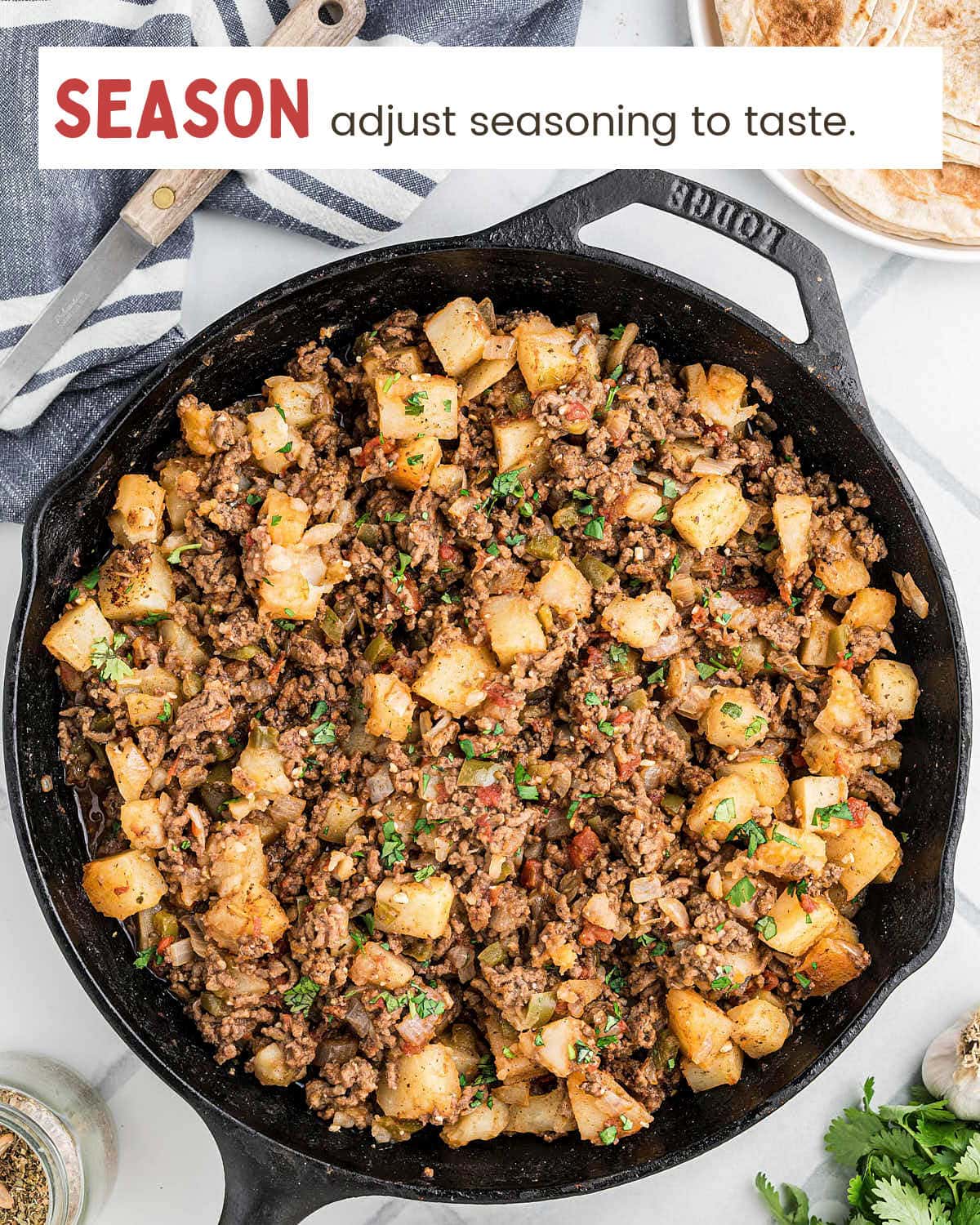 Cooked Picadillo in a cast iron skillet to be seasoned to taste.
