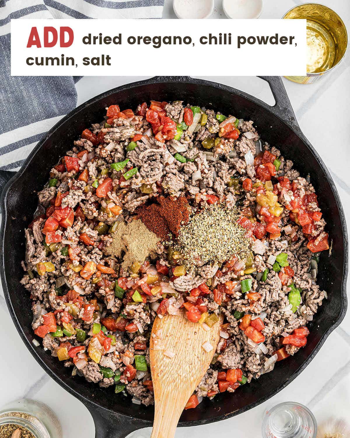 Dried oregano, cumin, and salt being added to the Picadillo meat mixture.