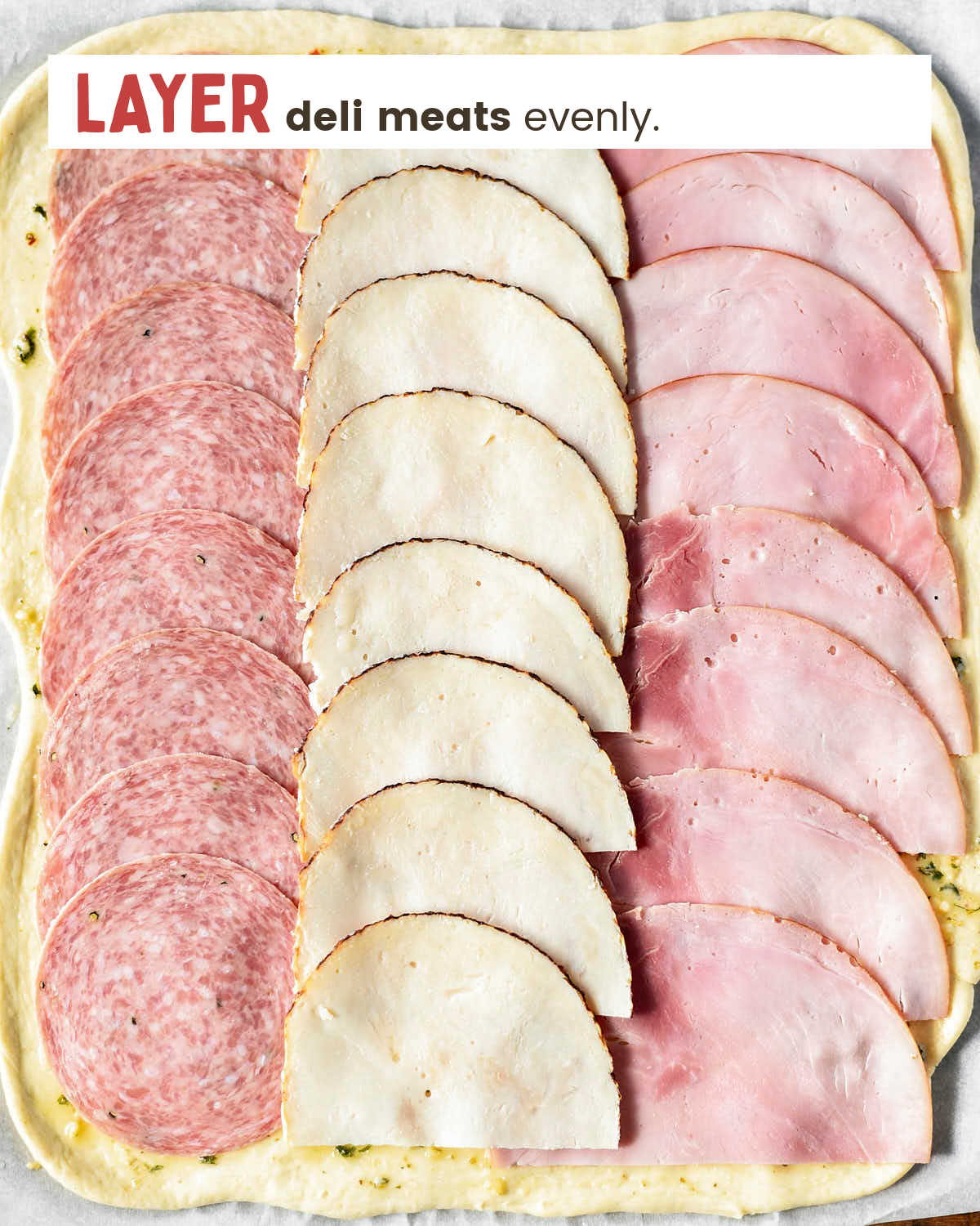 Layer deli meat on top of the pizza.