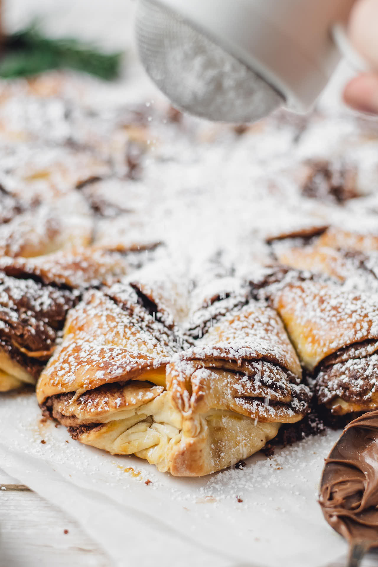 Adding a dusting of powdered sugar on top of the Star Bread.