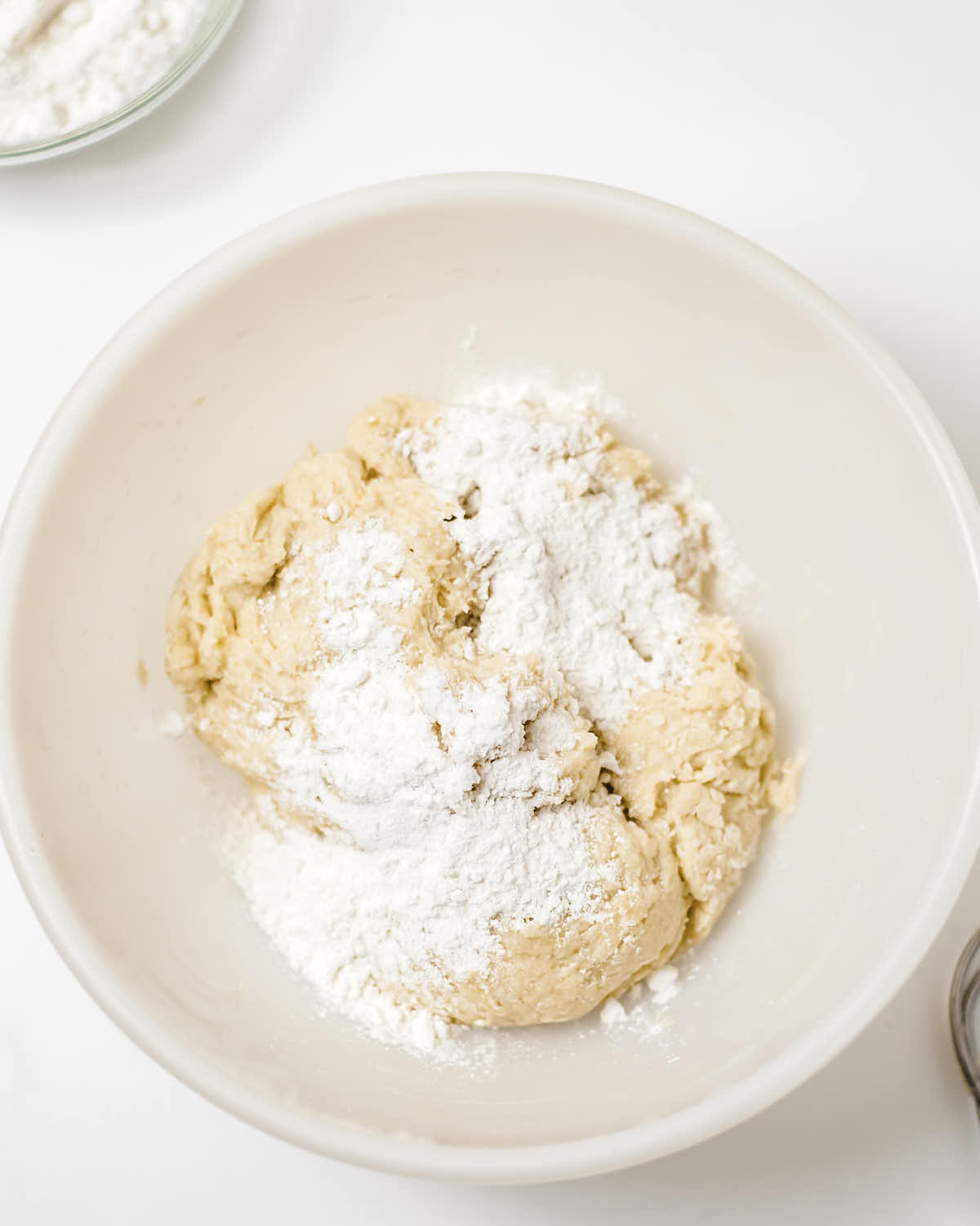 Adding flour to the dough to get the right consistency.