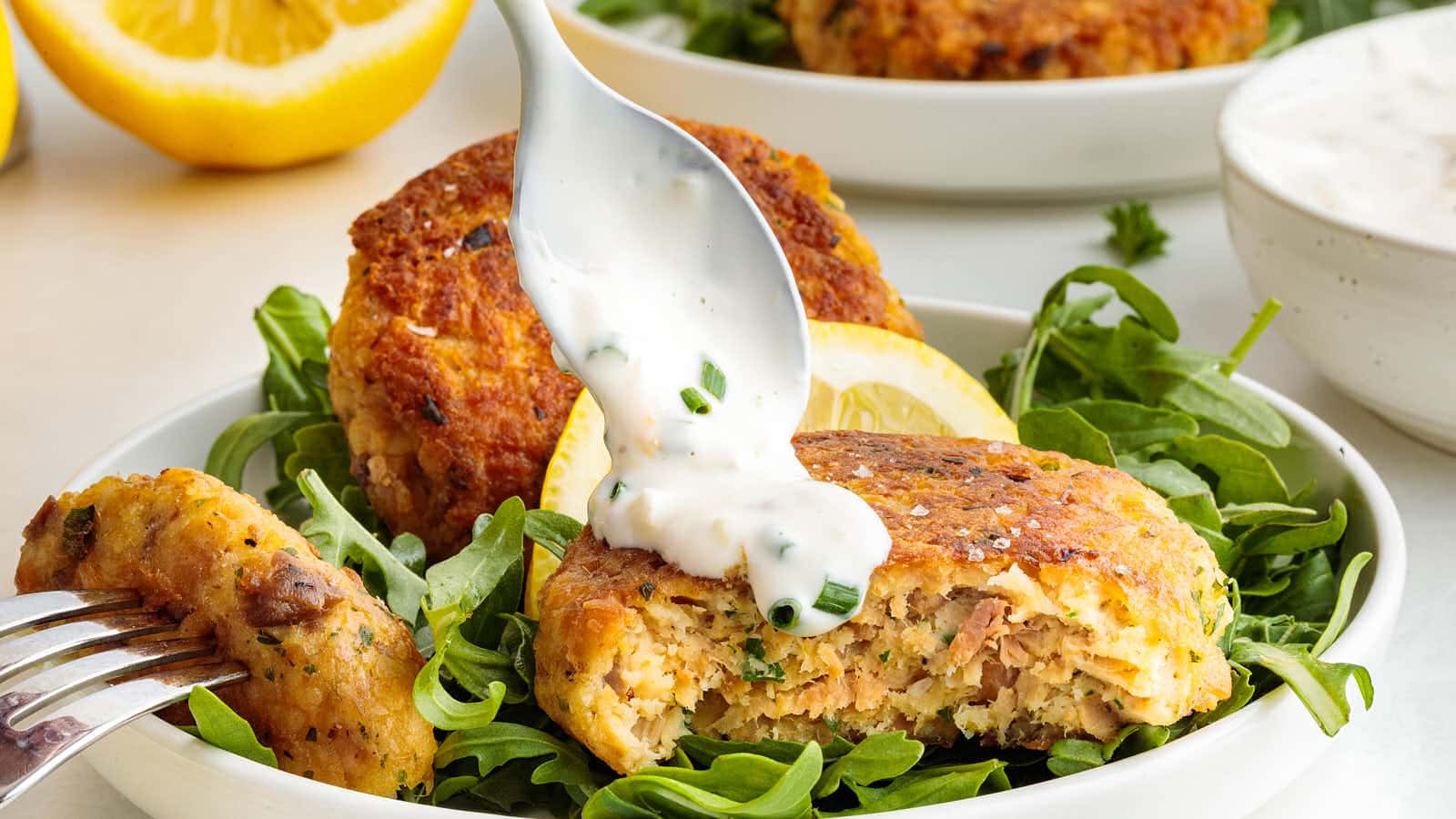 Salmon patty drizzled with creamy herb sauce served over fresh arugula greens.