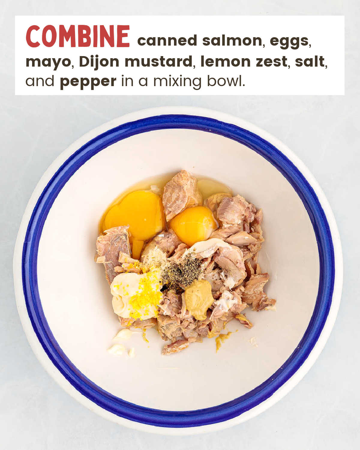 Salmon patty mixture fully combined in a white mixing bowl with a blue rim.