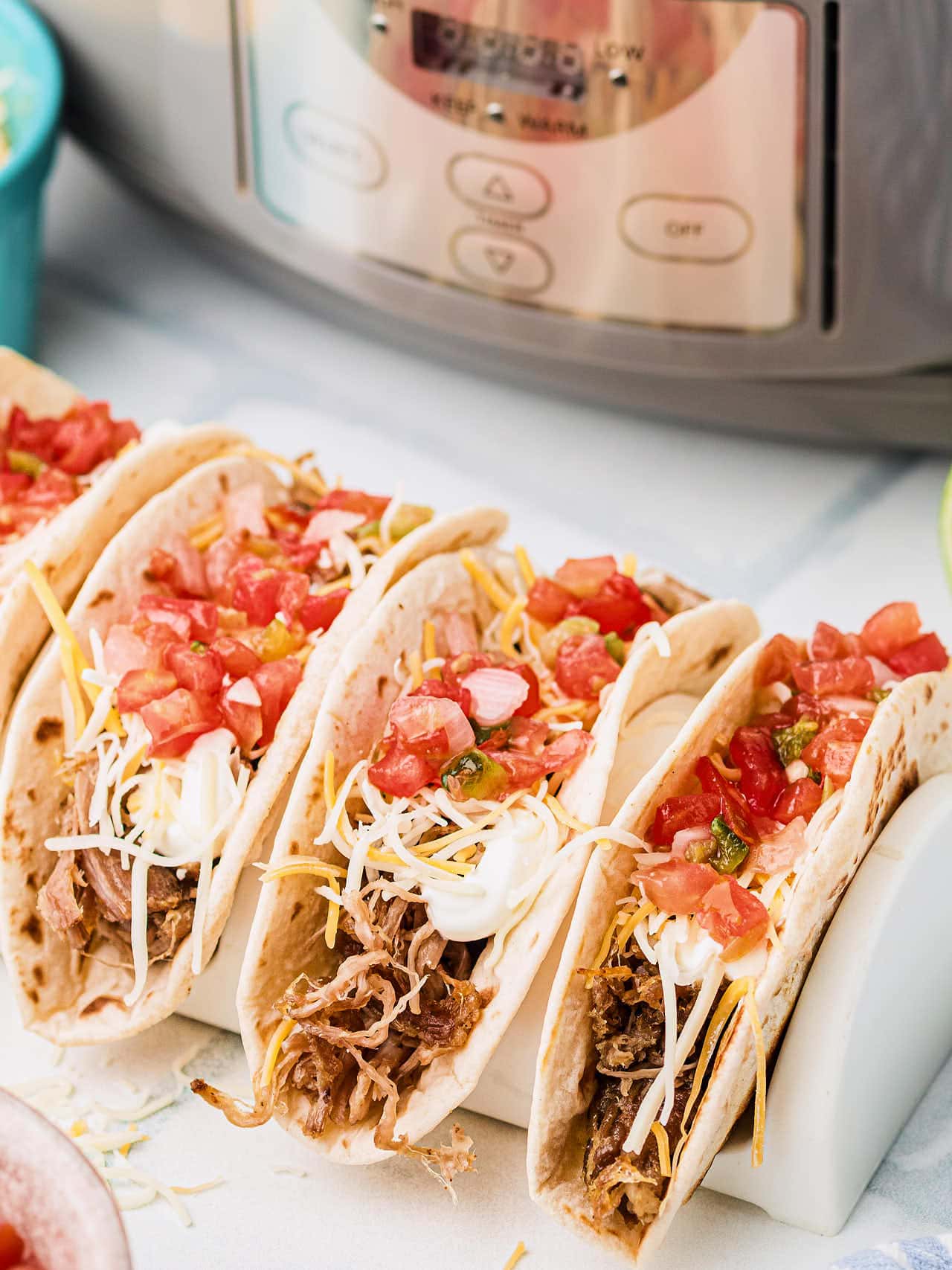 Slow cooker carnitas served in soft tacos with fresh toppings.