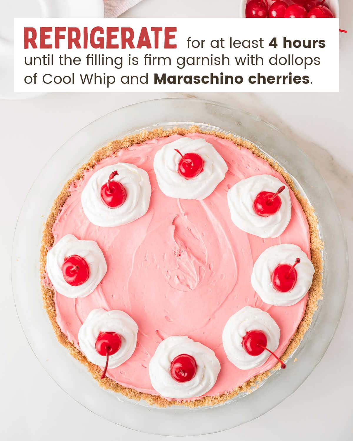 Kool Aid Pie topped with cool whip dollops and maraschino cherries viewed from above.