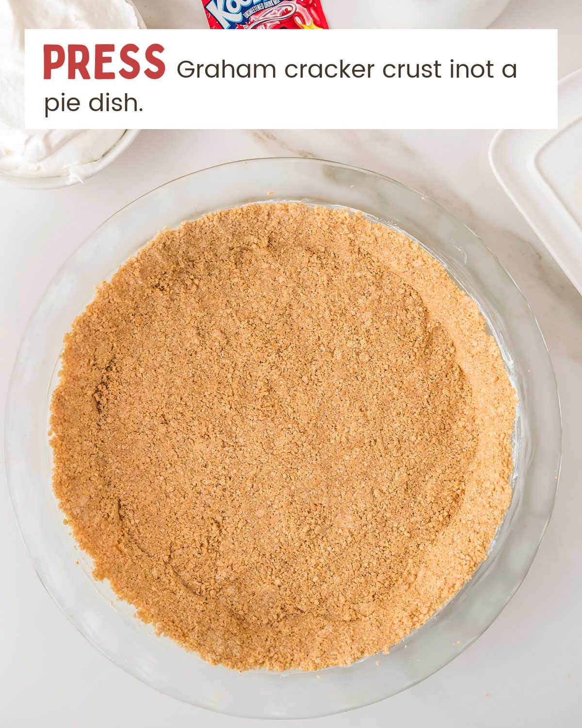 Graham cracker crust pressed into a glass pie dish for Kool Aid Pie.