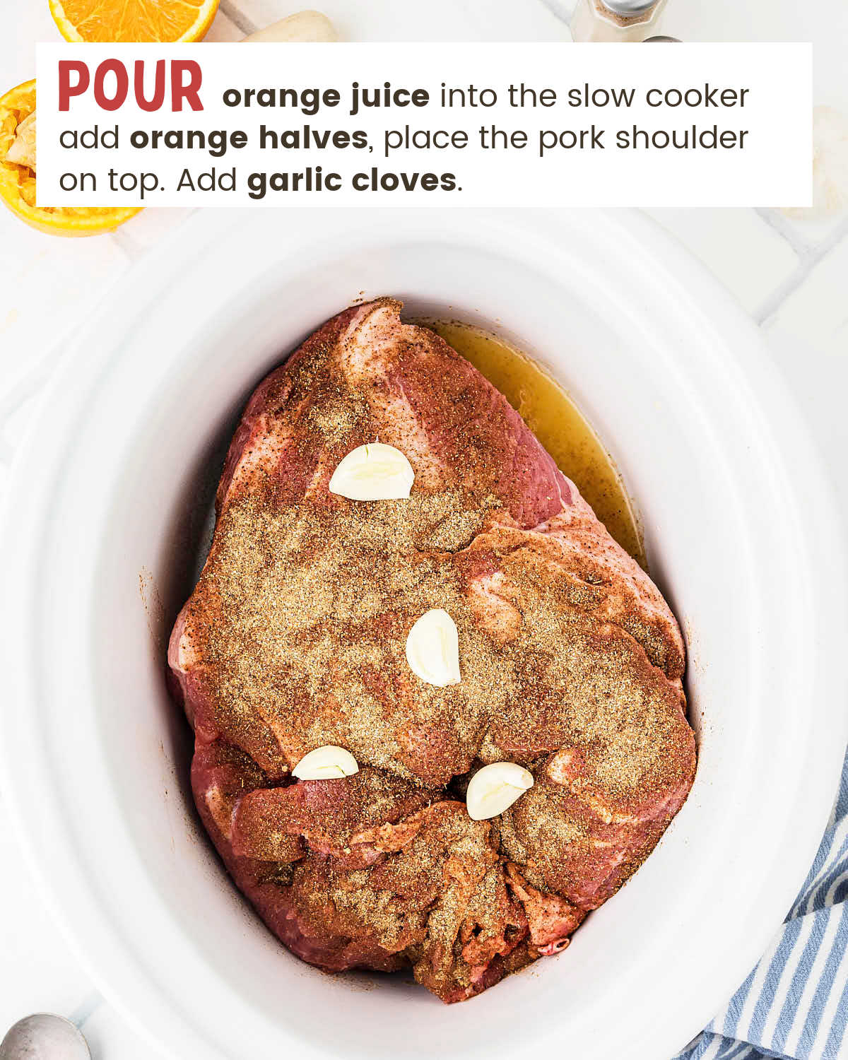 Seasoned pork shoulder with garlic cloves and orange juice in a slow cooker.