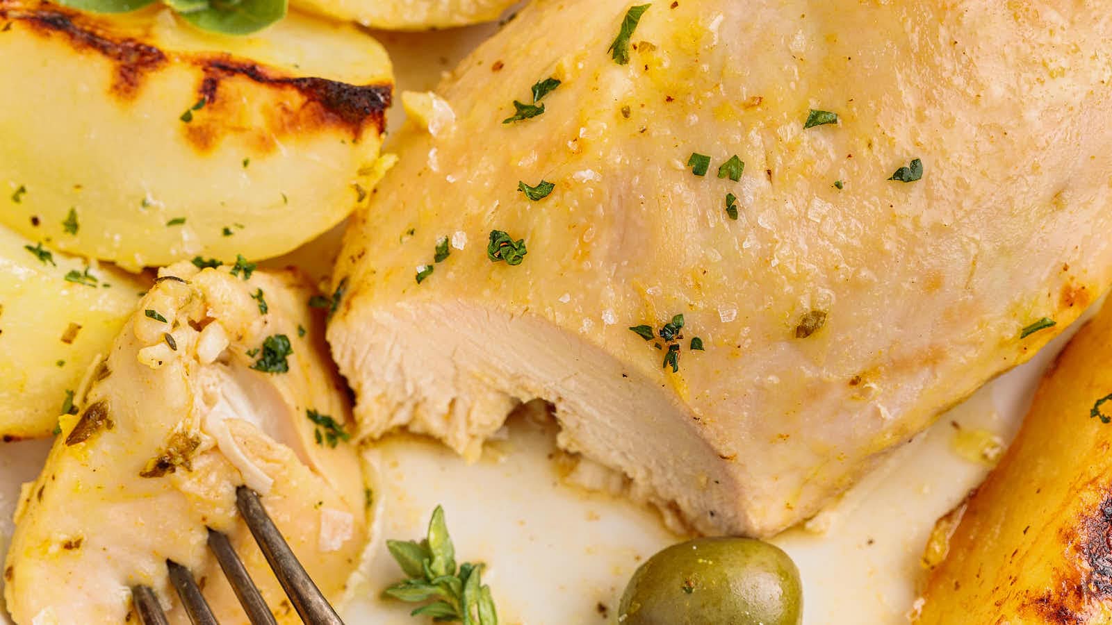 Sliced Greek Lemon Chicken and Potatoes showing the juicy inside, with a fork and a green olive.You said: I'm not berating myself, but what is wrong with my brain that I don't see this?