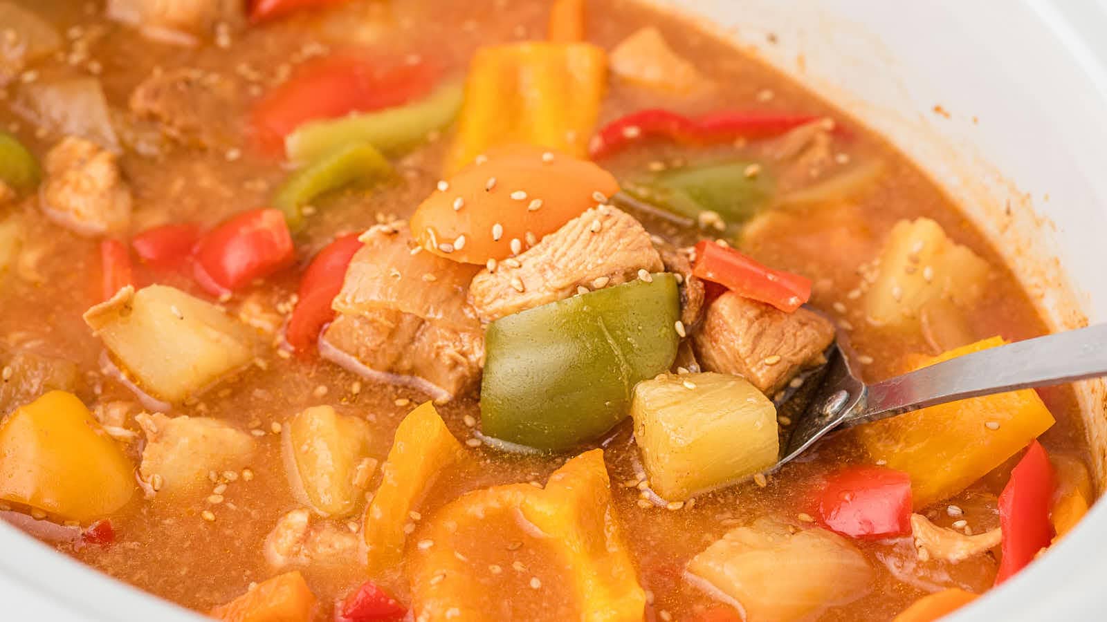 A spoonful of Crockpot Sweet and Sour Chicken with pineapple and green bell pepper.