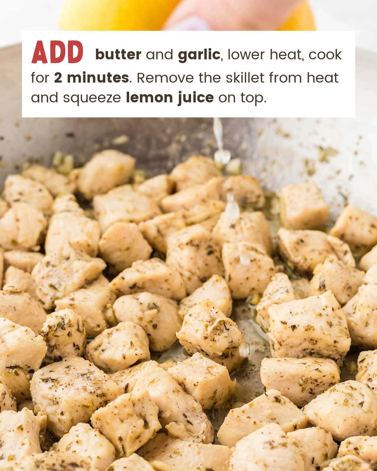 Fresh lemon juice being squeezed over cooked chicken in a skillet for Garlic Butter Chicken Bites.