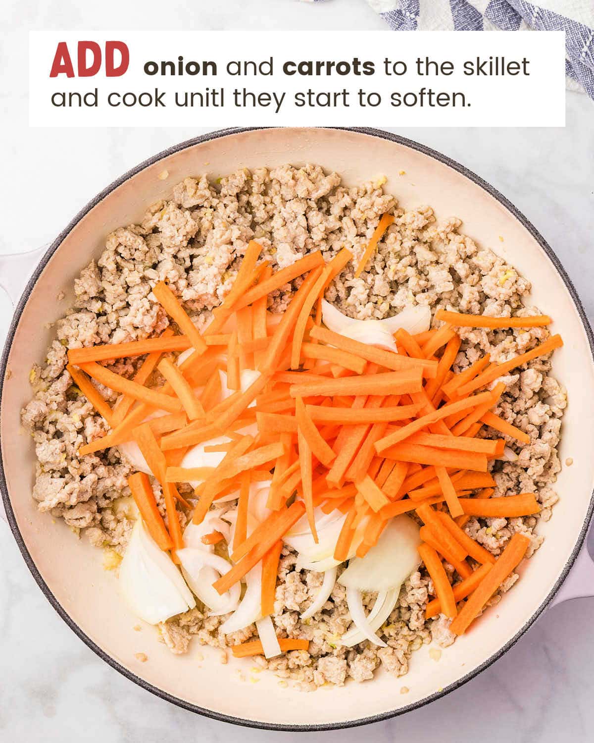 Sliced onion and julienned carrots added to the browned chicken.