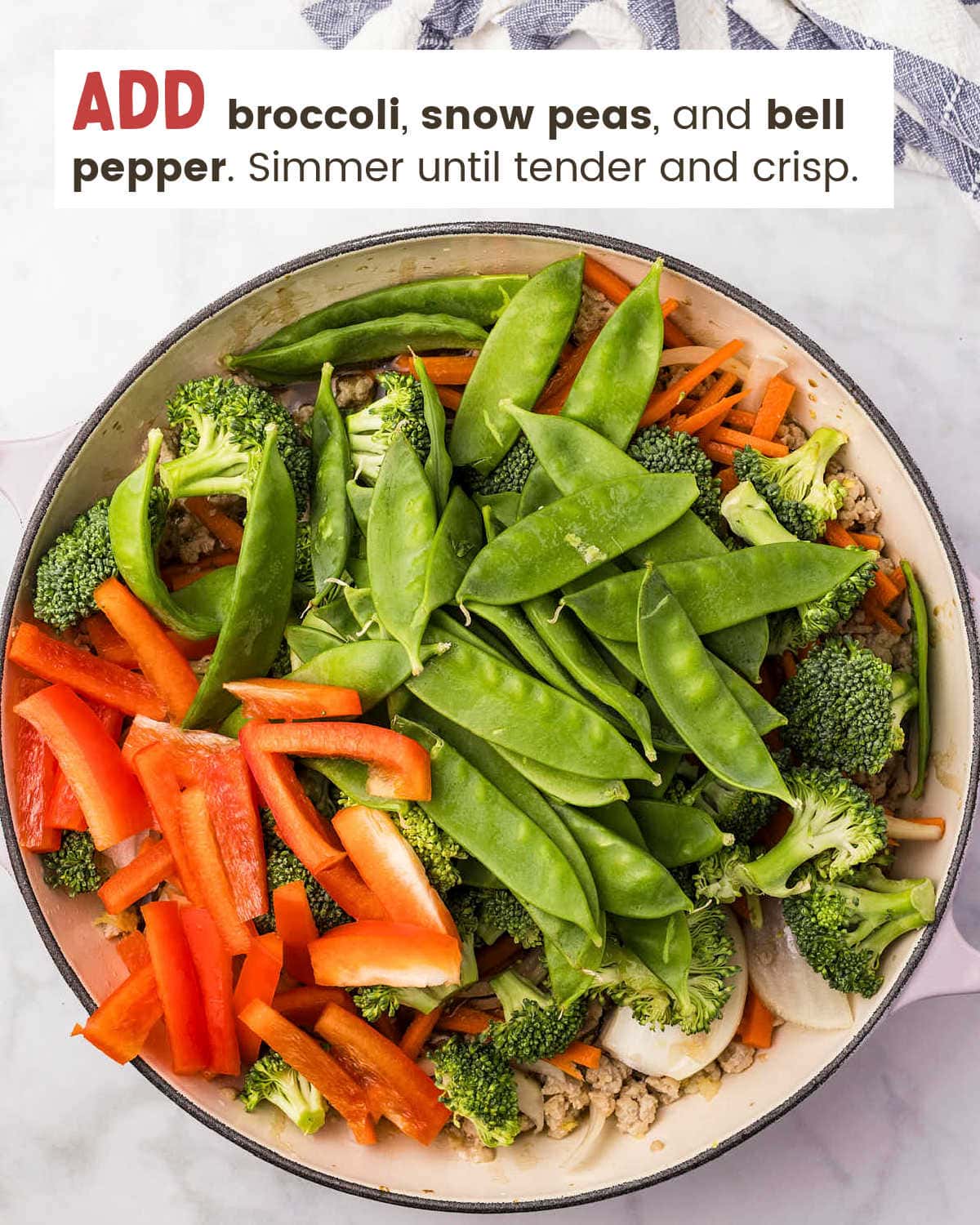 Broccoli, snow peas, and red bell pepper added to the pan.