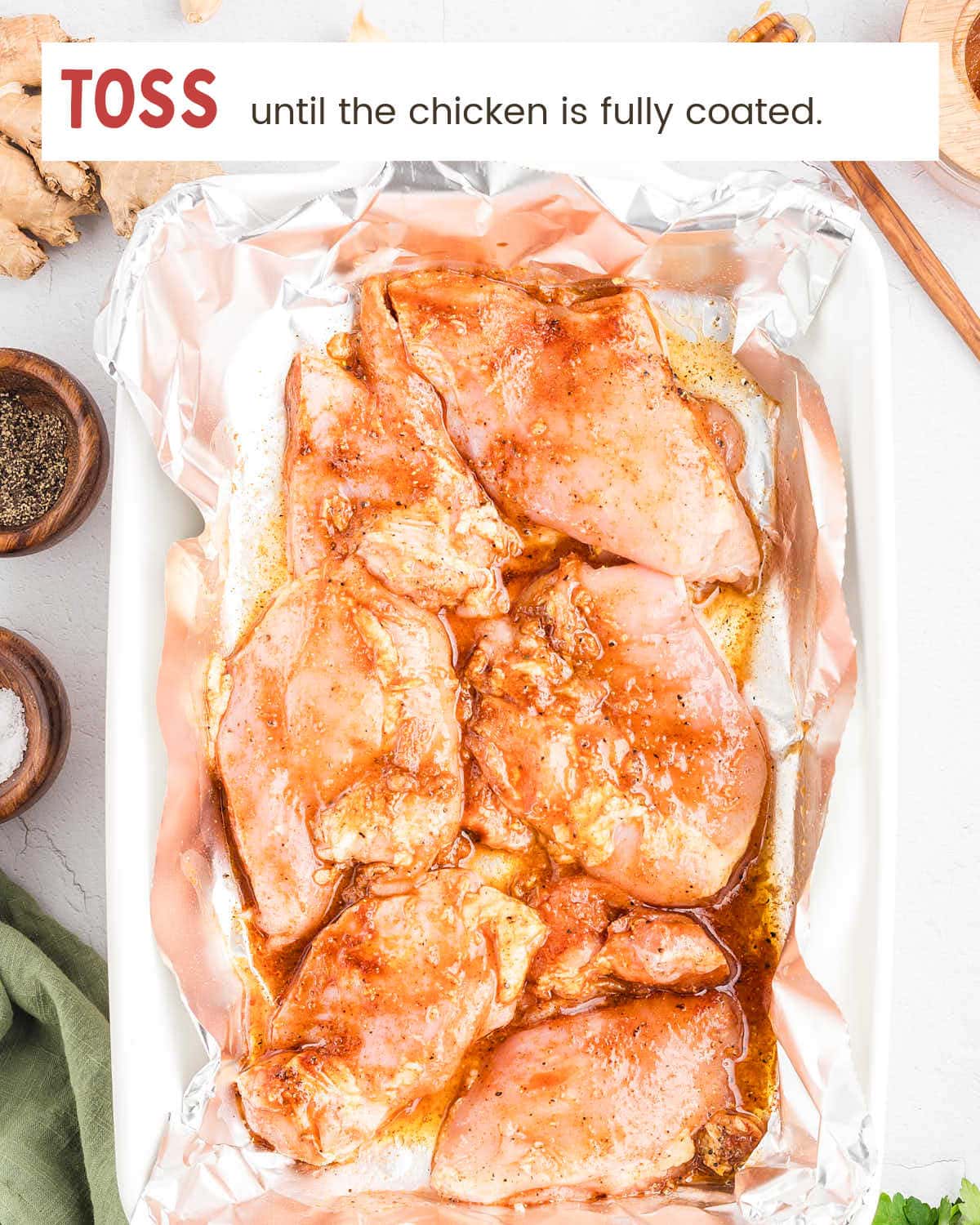 Seasoned chicken thighs tossed and coated in the honey garlic sauce before baking.
