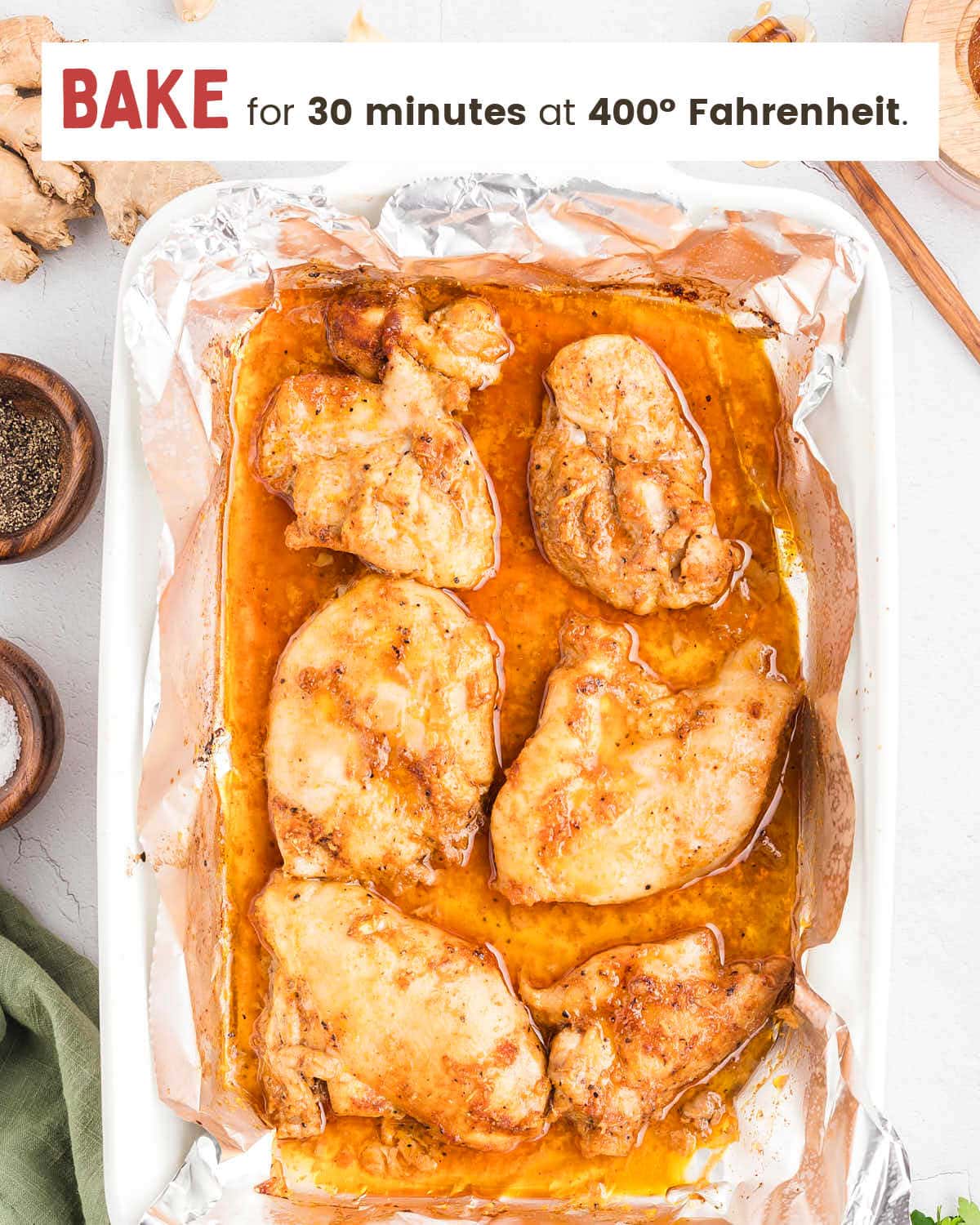 Baked Honey Garlic Chicken Thighs in a foil-lined dish with pan juices before saucing.