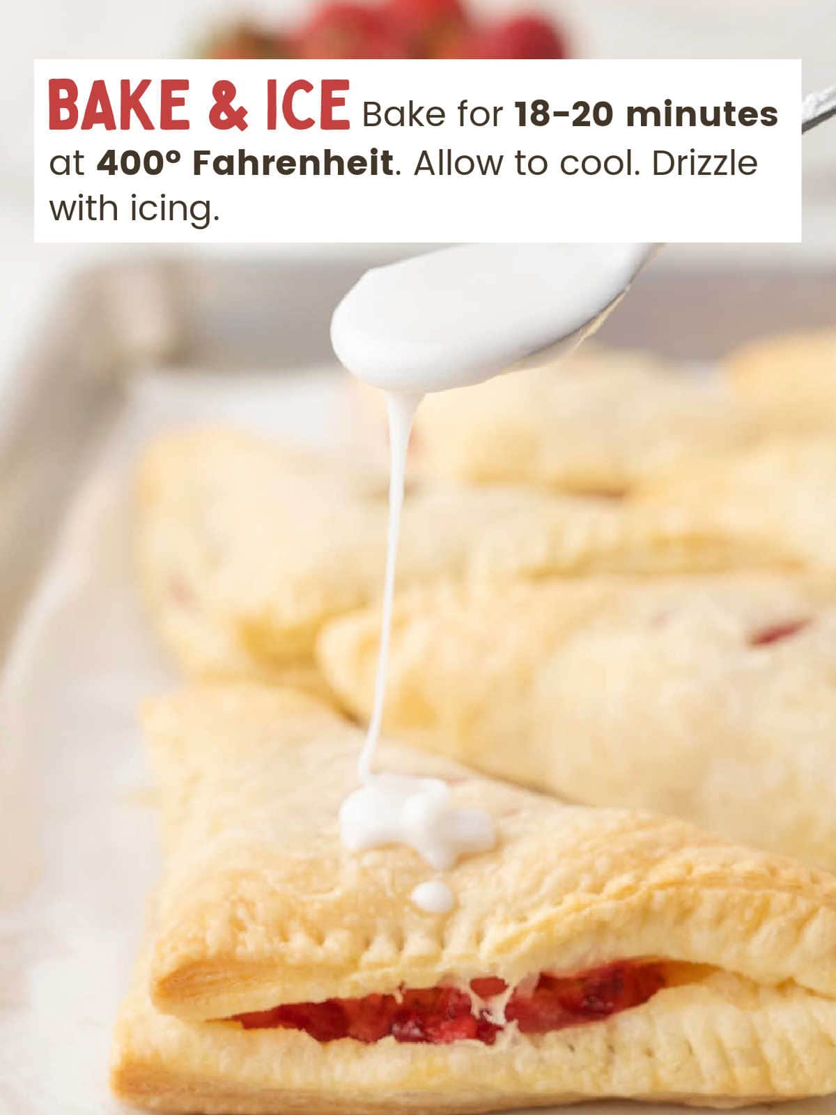 Icing drizzled over baked Strawberry Turnovers on a baking sheet.