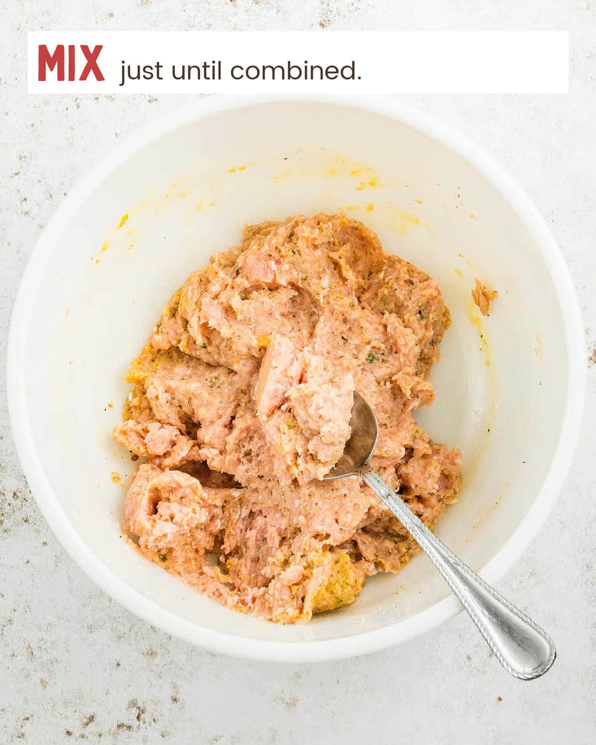 The mixed Buffalo Chicken Meatball mixture in a bowl with a spoon.