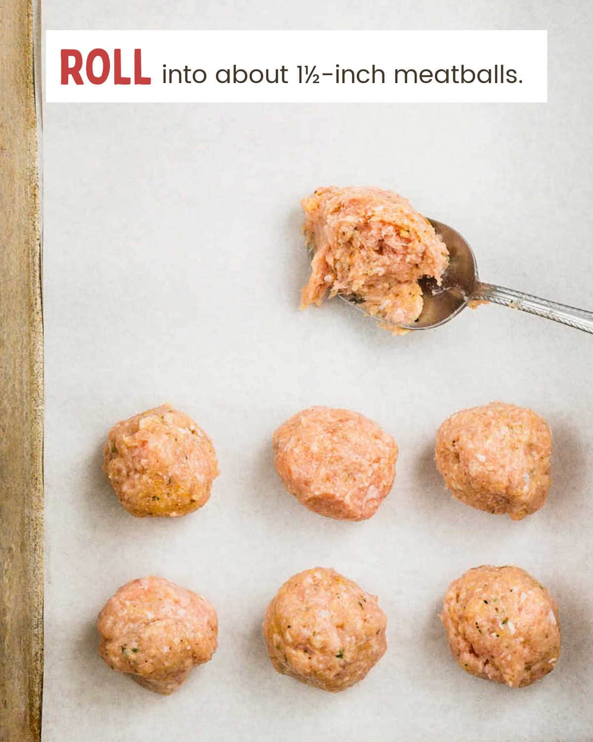Raw Buffalo Chicken Meatballs rolled and spaced on a parchment-lined baking sheet.