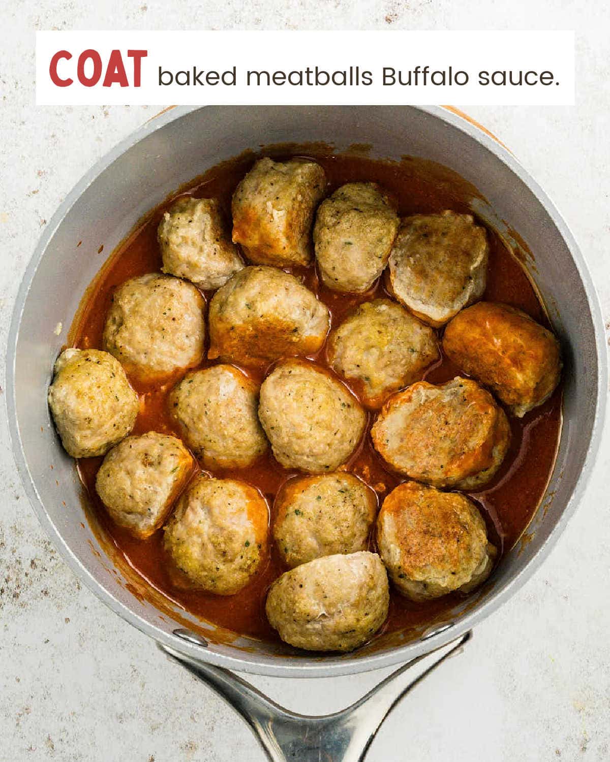 Buffalo Chicken Meatballs coated in warm buffalo sauce in a saucepan.