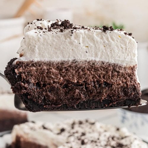 Close-up of a Mississippi Mud Pie slice showing the crust, brownie, mousse, and whipped cream layers.