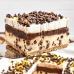 A slice of Cannoli Delight lifted from the baking dish on a serving spatula.