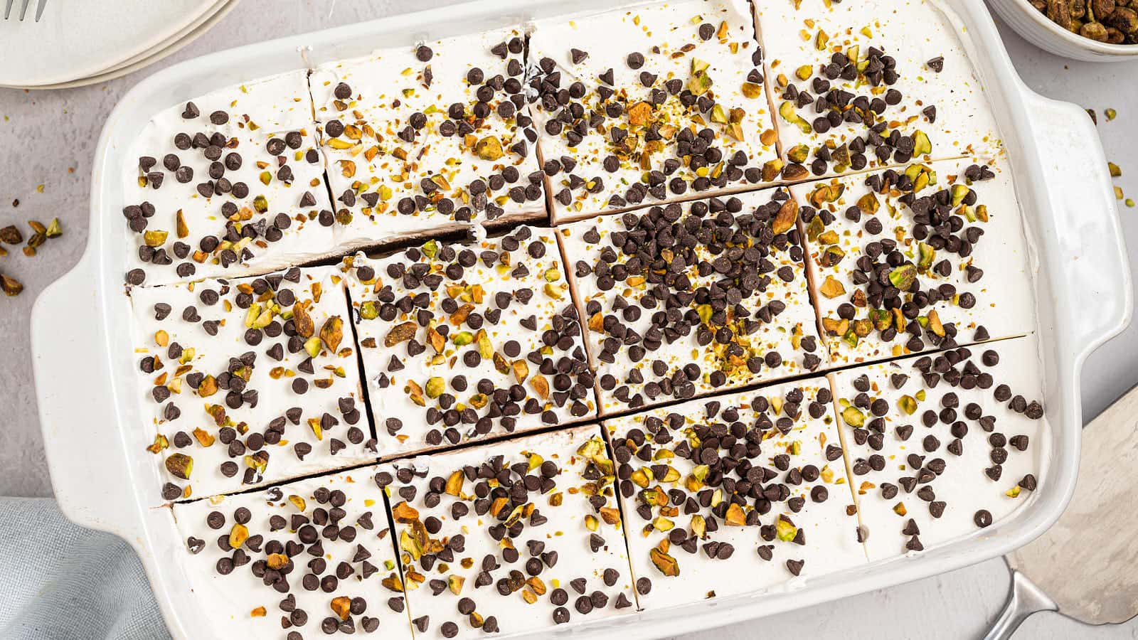 Overhead view of Cannoli Delight cut into squares in a white baking dish.