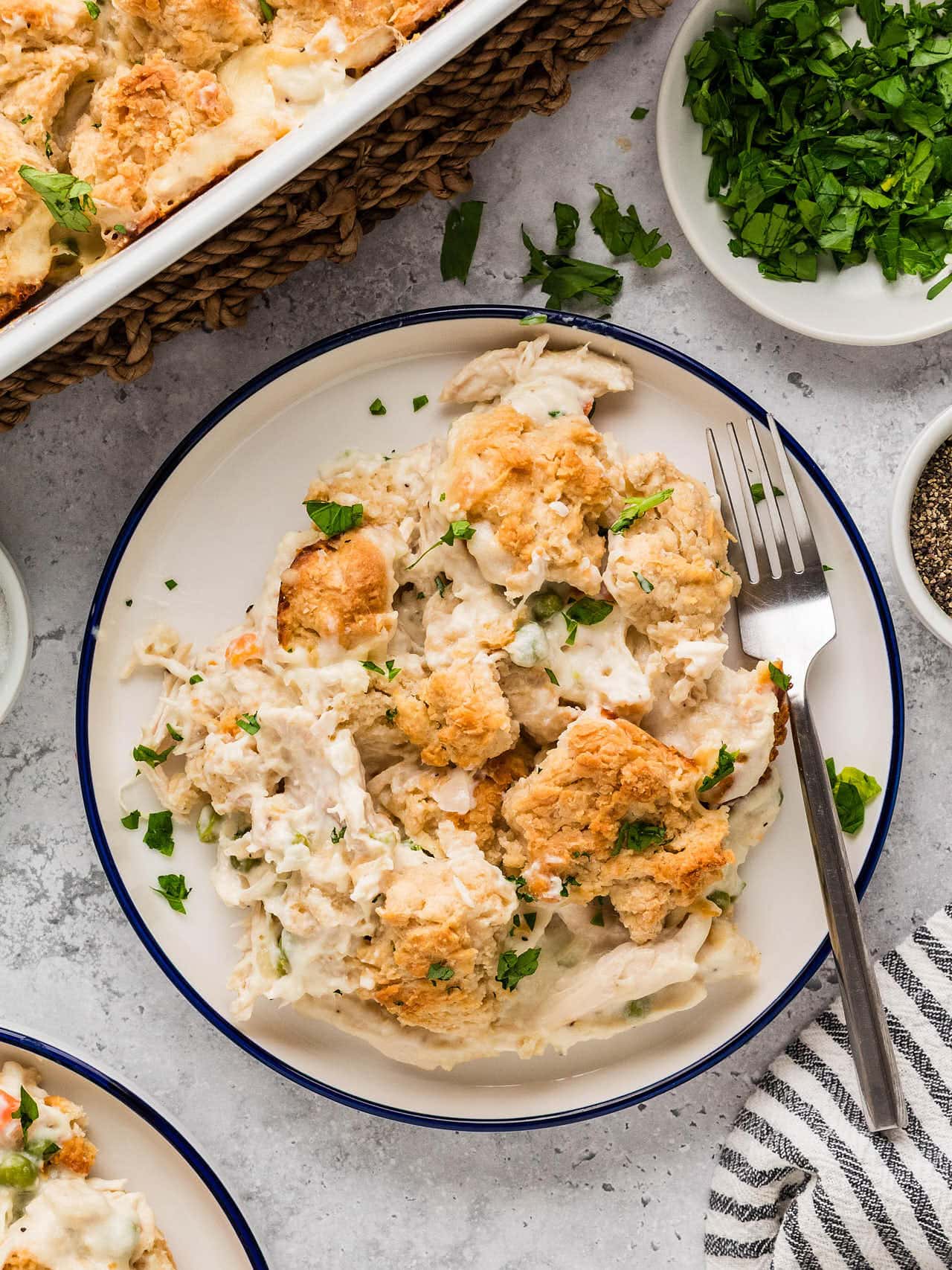 A plate of Chicken Cobbler with a fork beside the baking dish.