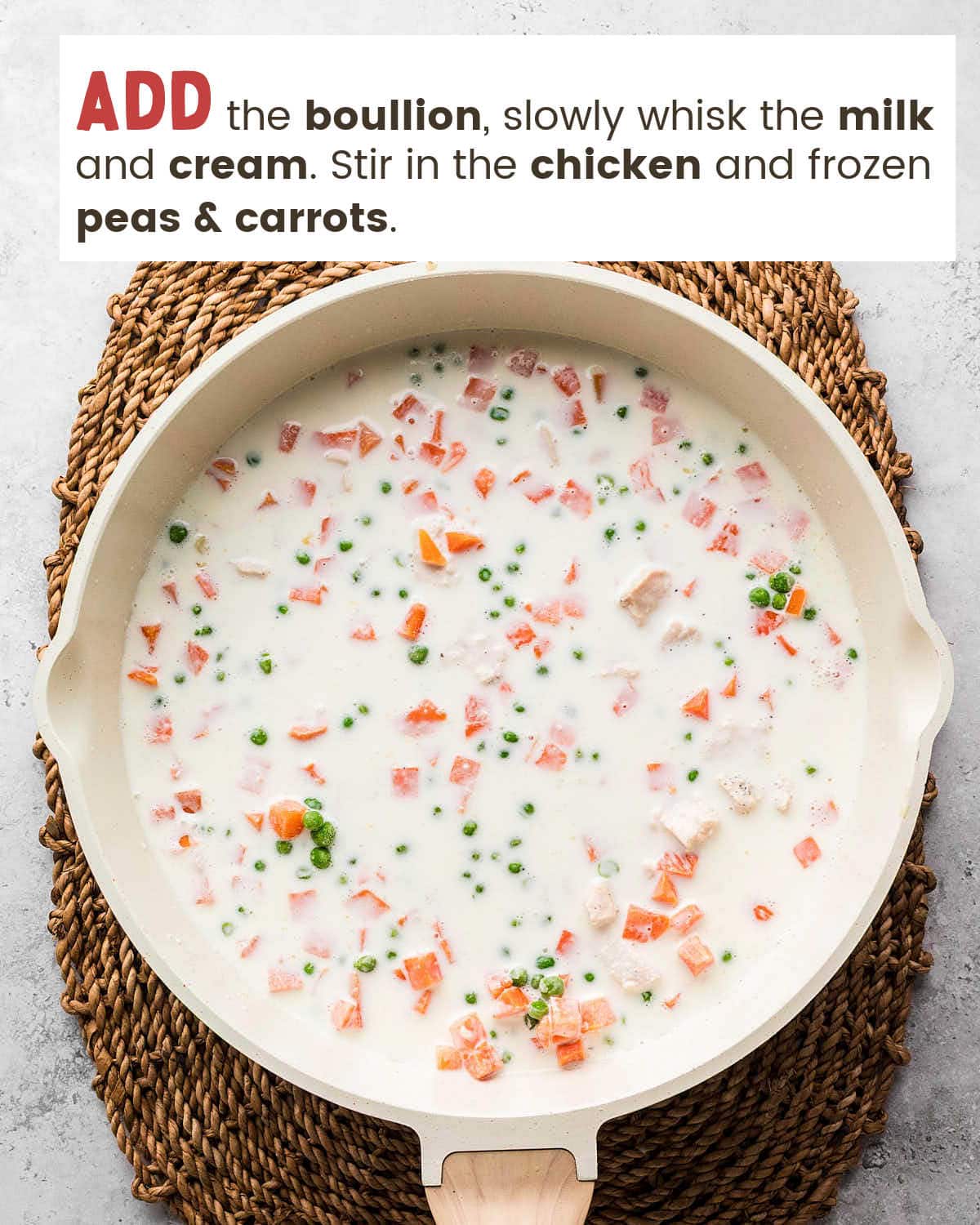 Creamy Chicken Cobbler filling with chicken, peas, and carrots in a skillet.
