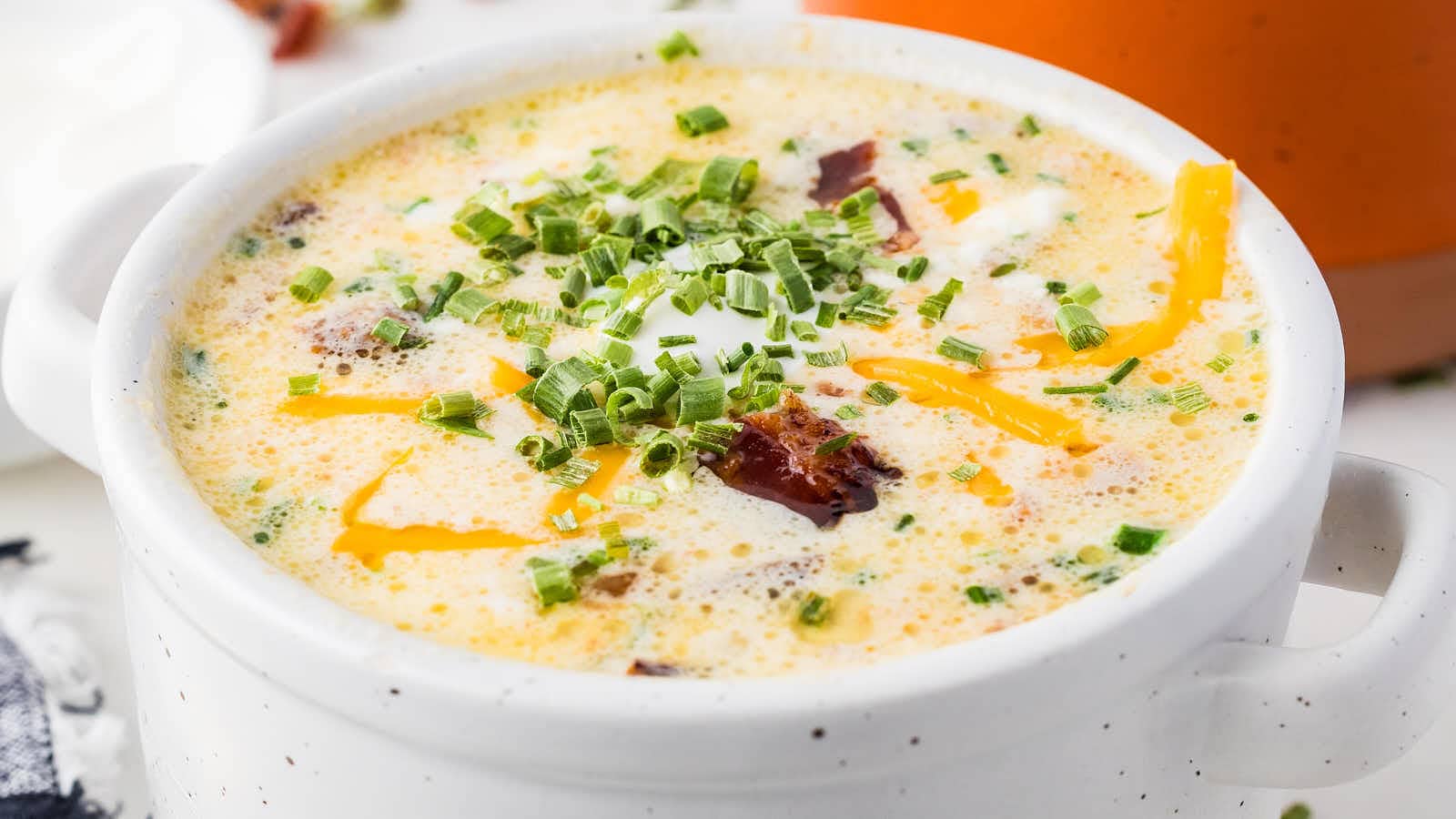 Crockpot Loaded Potato Soup topped with sour cream and bacon.