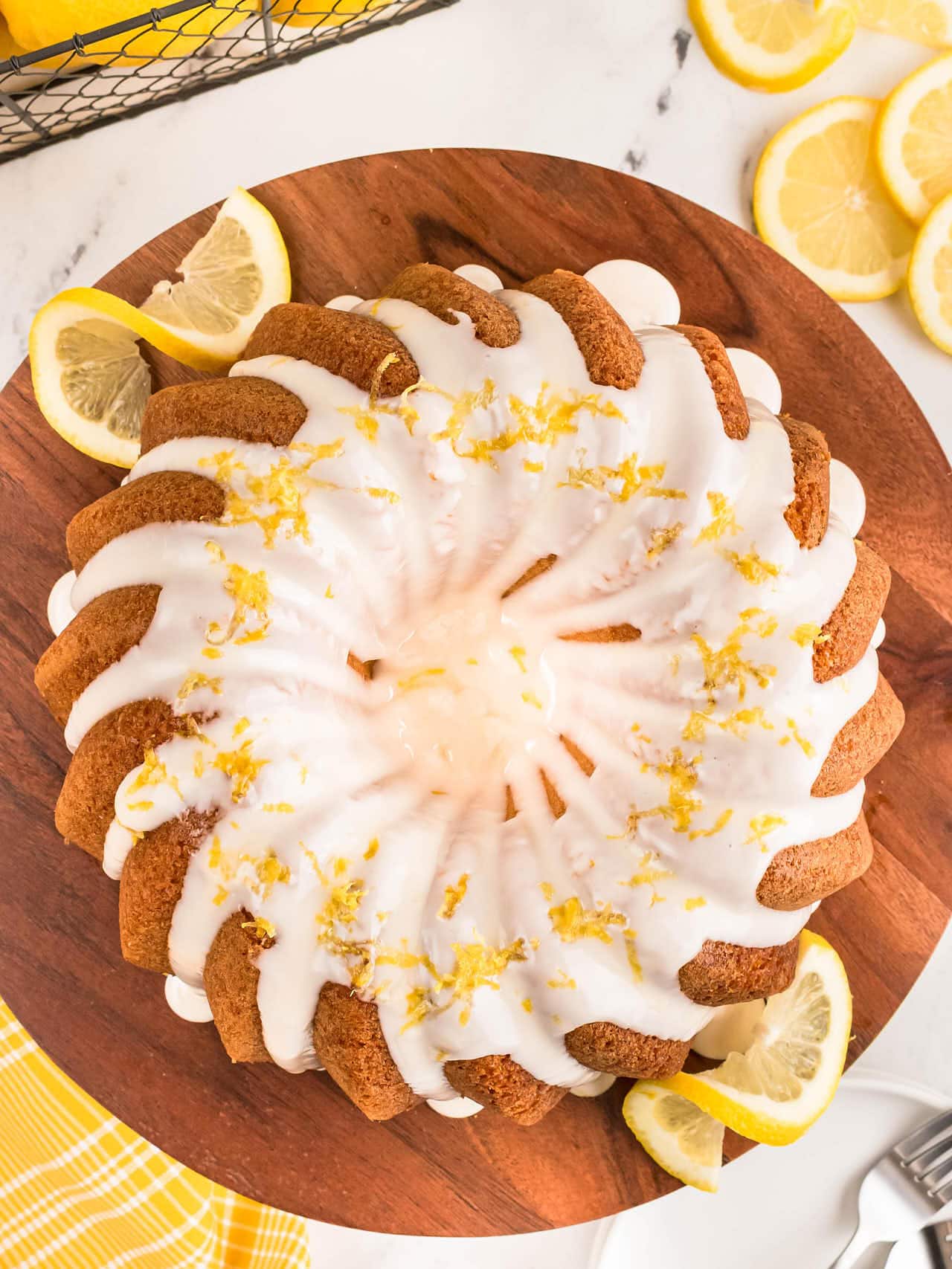 Overhead view of a Lemon Bundt Cake drizzled with glaze and ringed with lemon slices.