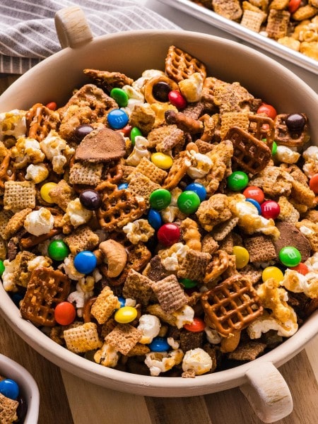 Sweet and Salty Chex Mix in a bowl with pretzels, popcorn, cashews, and colorful M&Ms.