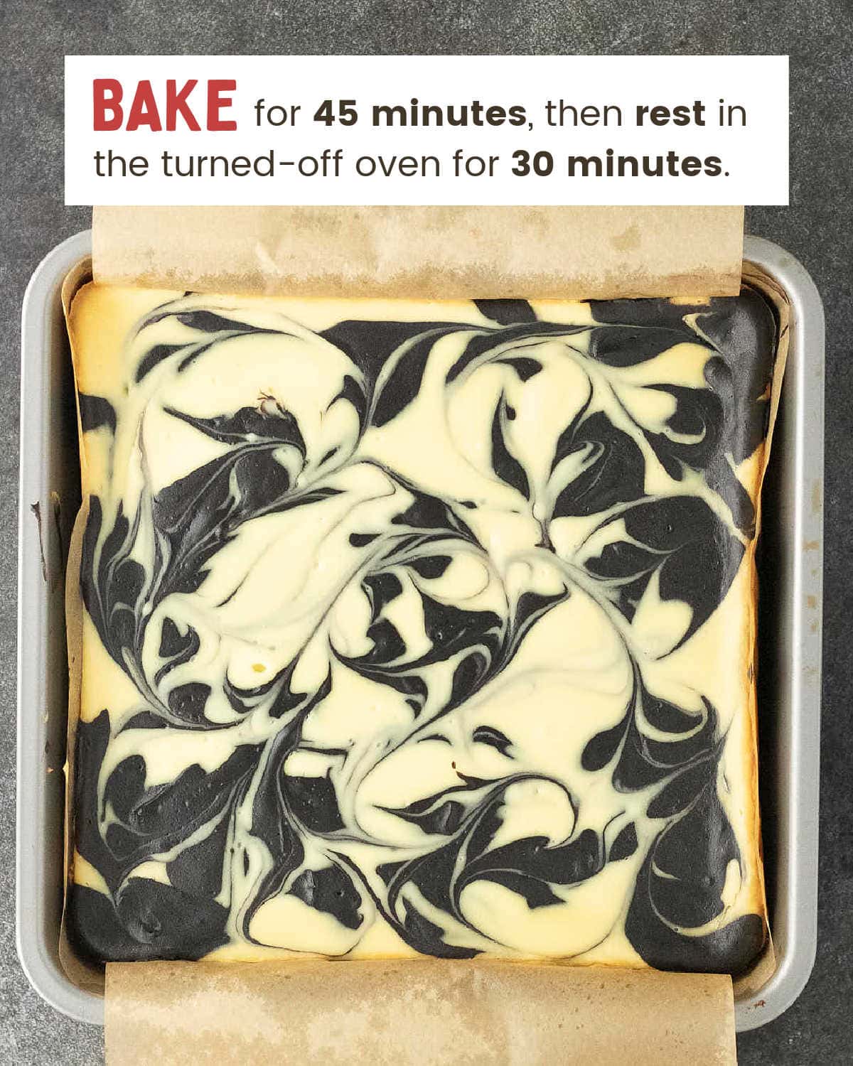 Baked Halloween Cheesecake Bars cooling in the pan with a marbled swirl top.