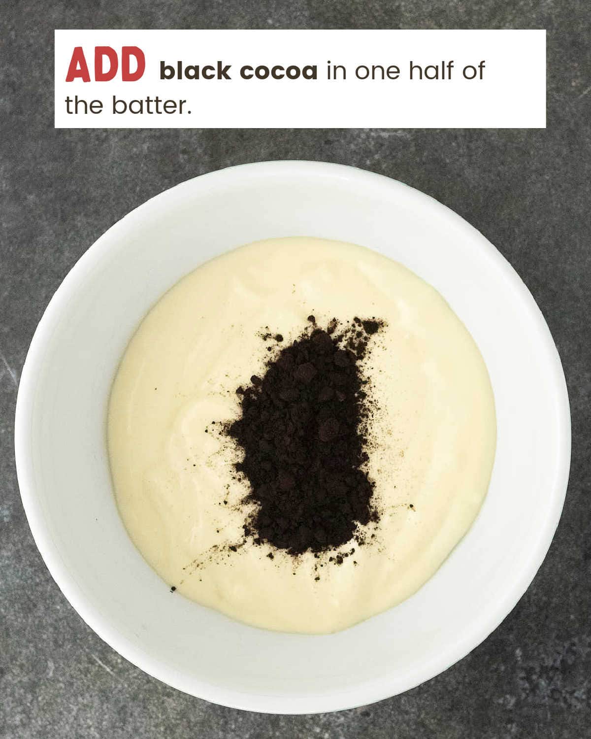 Black cocoa added to half the cheesecake batter in a white bowl.