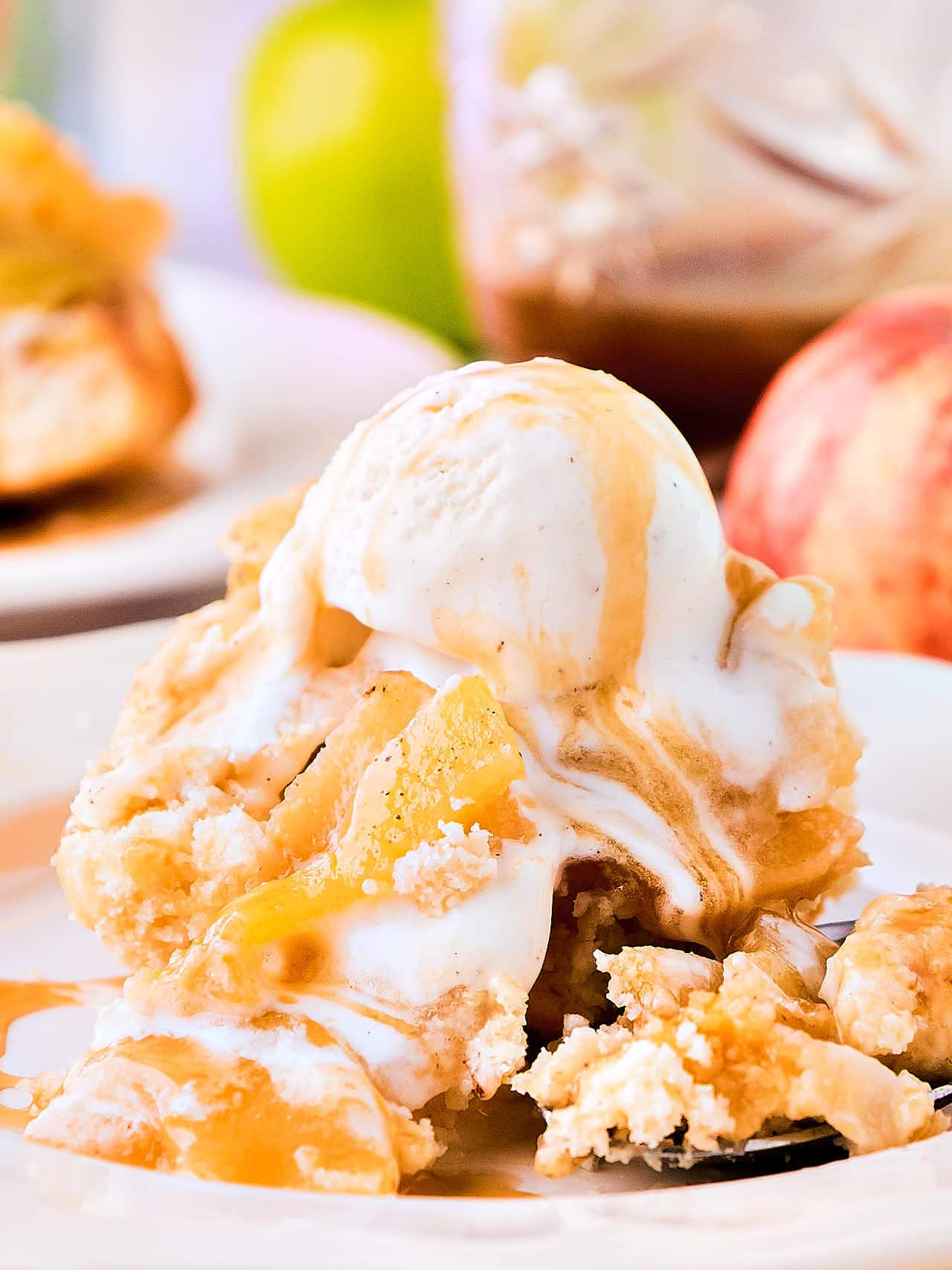 Vanilla ice cream and caramel sauce melting over a warm serving of Apple Cobbler.