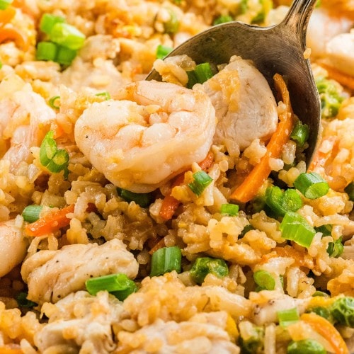 Chicken and Shrimp Fried Rice piled high on a serving spoon over the skillet.