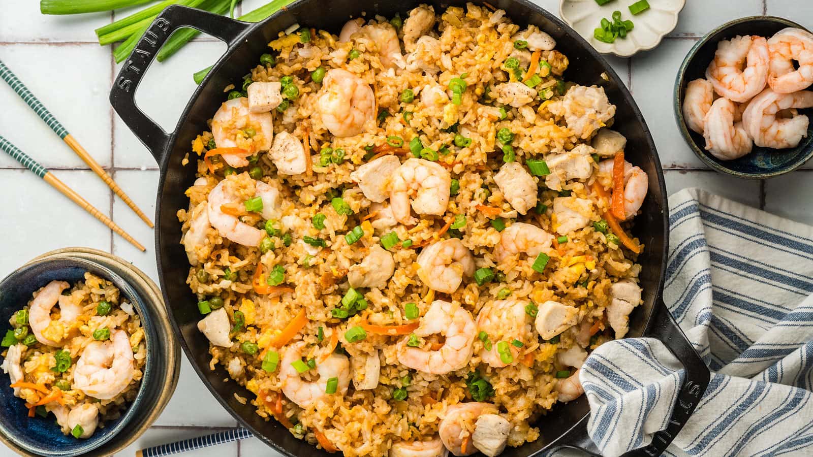 Chicken and Shrimp Fried Rice in a large skillet with serving bowls.