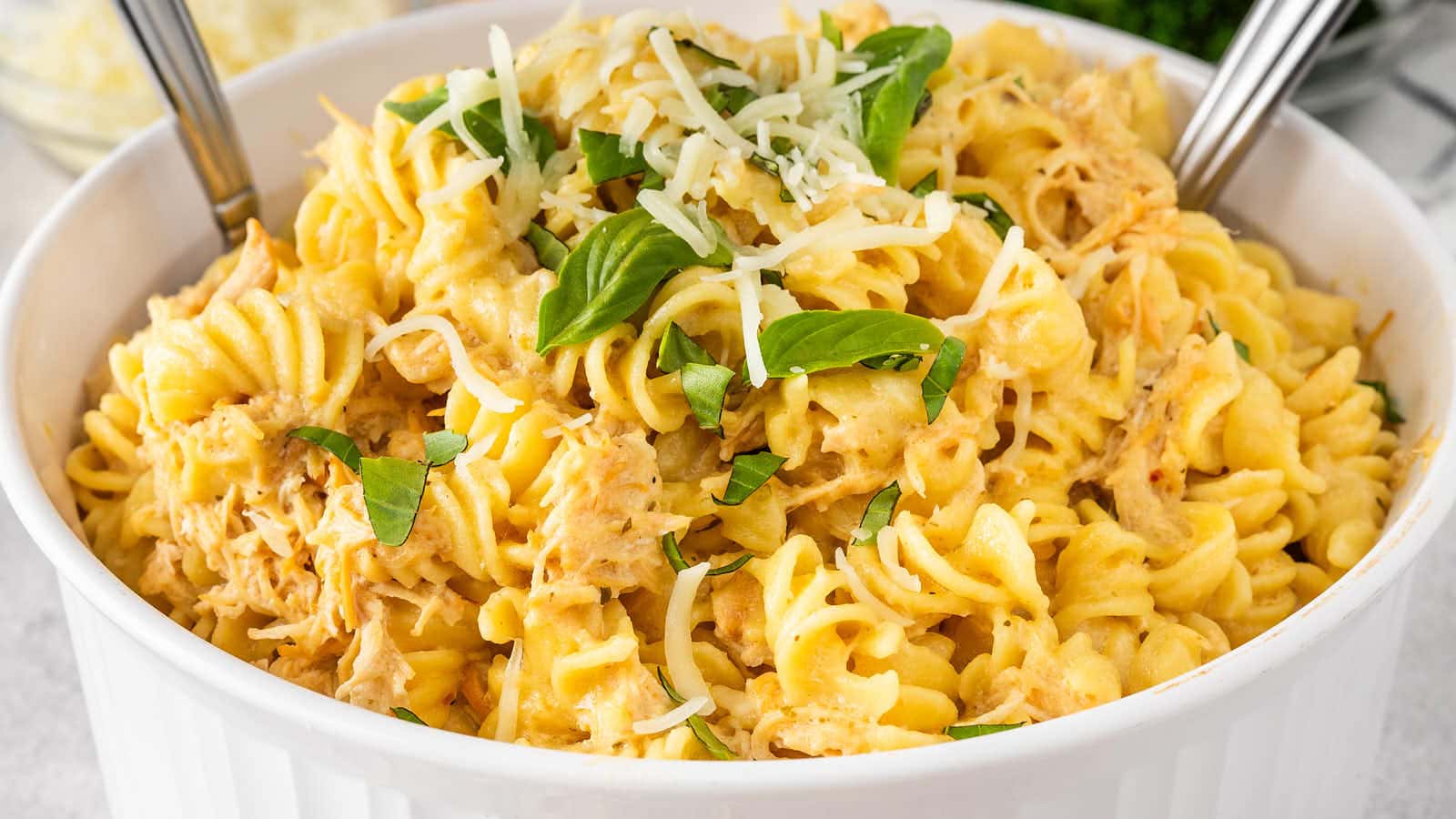 Serving spoons in a big bowl of Olive Garden Chicken Pasta.
