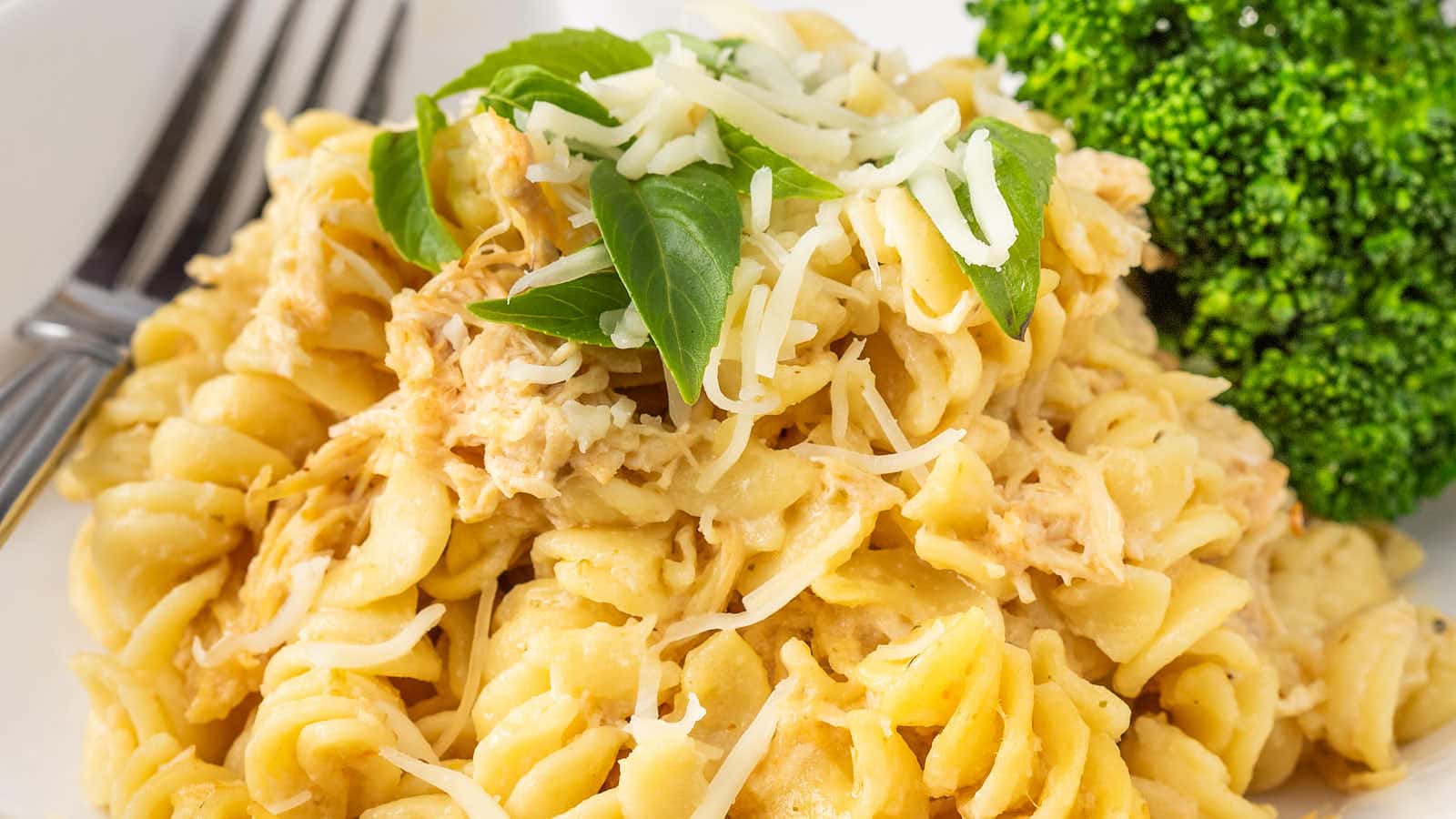 A plated serving of Olive Garden Chicken Pasta with broccoli and a fork.