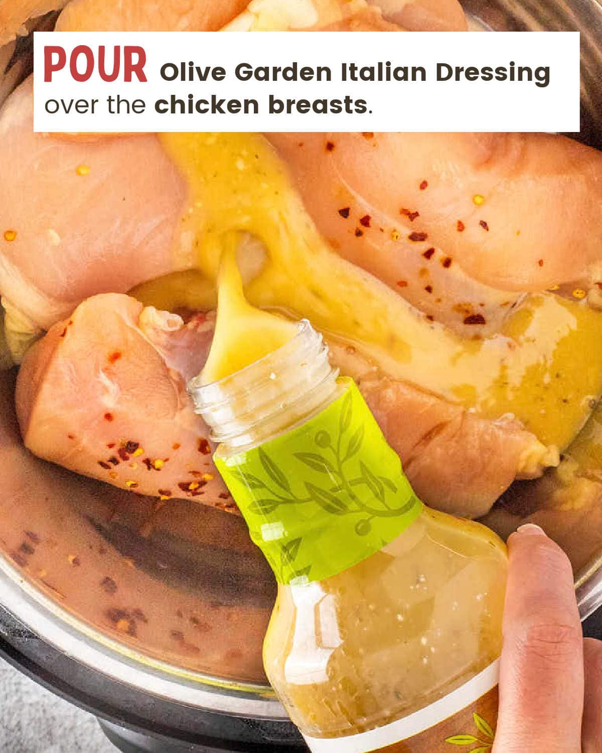 Pouring a bottle of Olive Garden Italian Dressing over chicken breasts in a crock pot.