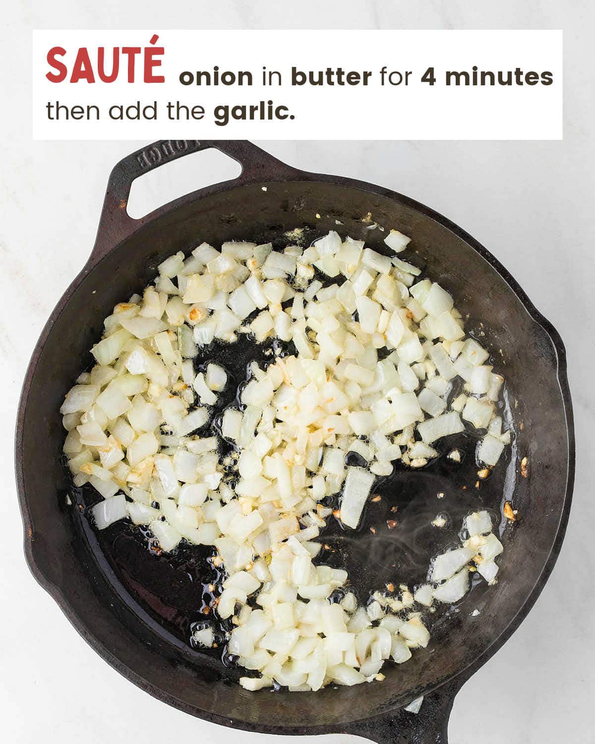 Diced onion and garlic sautéing in butter in a cast iron skillet for Crockpot Loaded Baked Potato Soup.