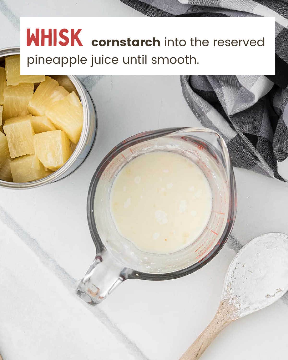 Cornstarch and pineapple juice slurry in a glass measuring cup next to canned pineapple chunks.