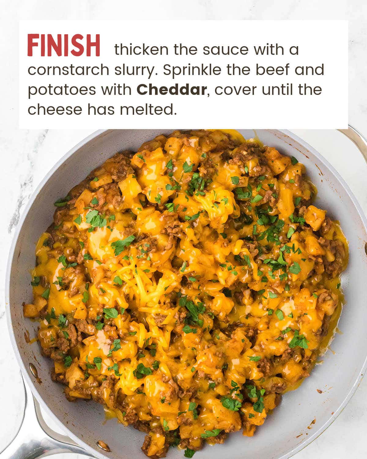 Cheddar melted over the finished skillet of Ground Beef and Potatoes with parsley.