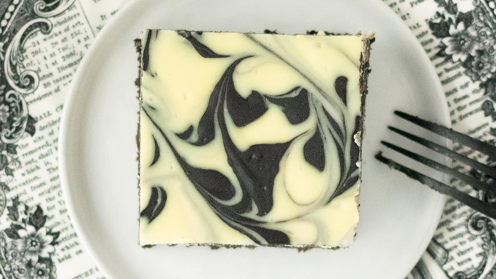 Overhead view of a single Halloween Cheesecake Bar with a black and white swirl top.