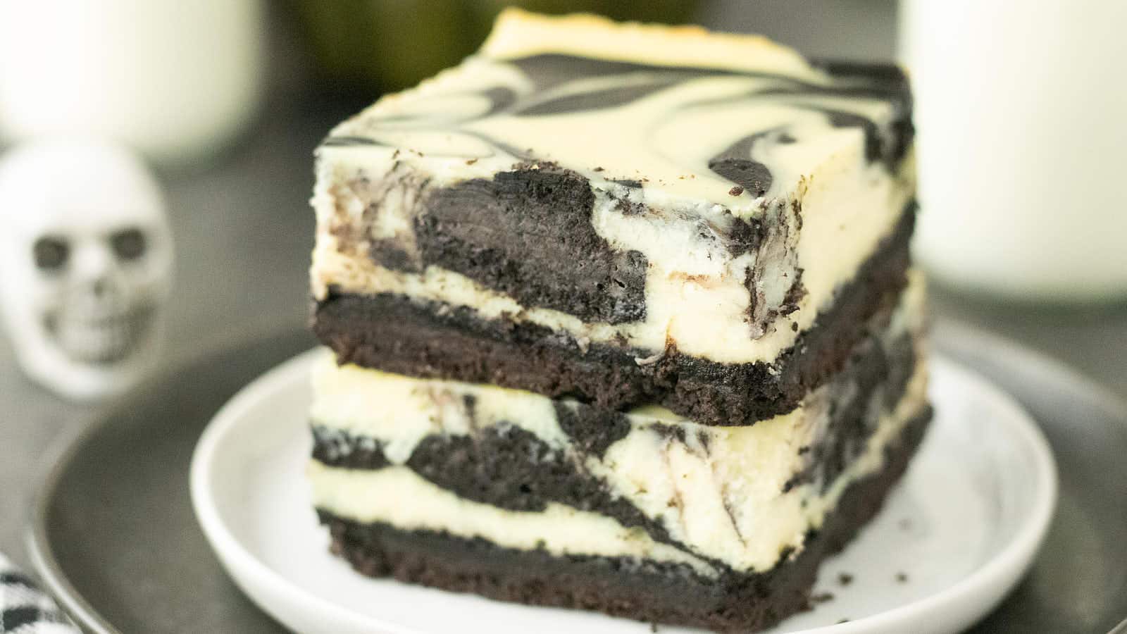 Two stacked Halloween Cheesecake Bars showing the black cocoa swirl and Oreo crust.