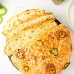 Overhead view of a sliced Jalapeño Cheddar Bread loaf on a slate board.